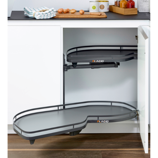 Kitchen pull-out drawer with chrome basket holding black bottles, white cabinetry, and gray floor
